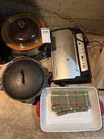 Group shot of all items: Dutch oven, slow cooker, FoodSaver, baking dish, towel