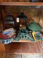 All items on shelf: two lanterns, sealed lights, two tree stands, ornaments