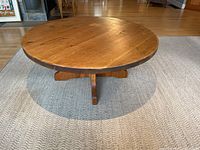 Full view of round wooden coffee table on rug