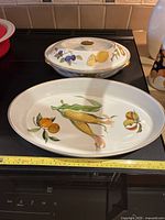 Large oval platter and covered vegetable dish on stove