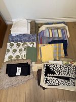 Full lot of assorted folded table linens laid on floor
