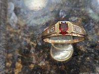 Top view of 10kt gold men’s ring with garnet and diamonds