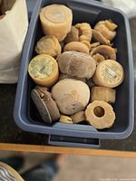 Plastic tote containing numerous used beeswax candle pieces of varying shapes and sizes