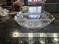 Side view of square pressed glass bowl beside ruler showing width