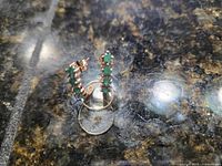 Earrings standing showing emerald and diamond settings