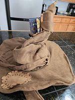Overall view of brown Harry Potter Sorting Hat with tag attached