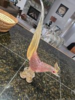 Full side view of pink Murano pheasant on granite counter