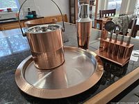 Entire bar set on counter: tray, ice bucket, cocktail shaker, bar tool stand with tools