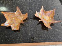 Pair of iridescent glass leaf-shaped dishes on countertop
