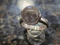 Close-up of ring showing clear round rock crystal and sterling setting