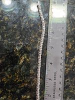 Full view of sterling silver twisted rope bracelet beside ruler showing ~7.5 inch length