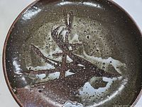 Top view of glazed stoneware plate showing abstract design and glaze colors