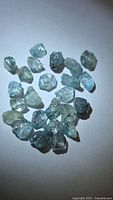 Group of light blue rough zircon crystals on white background