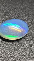 Top view of oval crystal opal showing blue and green play-of-color