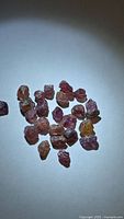 Group of small multicolored rough sapphire crystals on white background