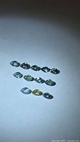 All 11 multicolored pear-cut sapphires laid out on white background
