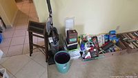 Lot overview showing vacuum, stool, bucket and boxed cleaning supplies