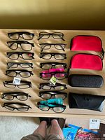 Full lot overview of 16 glasses and four cases laid on table