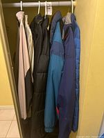 Seven jackets hanging on rod
