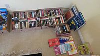 Overview of three boxes filled with paperbacks plus several large hardcovers and music books on floor