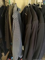 Multiple jackets, shirts and ties on hangers