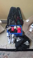 Overall lot showing bags, racquets, crate, shoes, pads