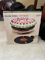 Front cover of Rolling Stones Let It Bleed with other records behind