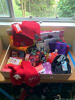 Overview of lot in a bin showing Marvel beanies, mittens, zip pouch, scarves, gift bags