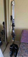 Full view of Rossignol Bandit B2 skis standing upright with Lange boots at base