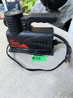 Full view of compact air compressor with power cord and hose