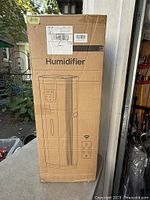 Front of sealed carton showing product illustration, Humidifier text, remote icon