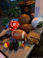 Overview showing basketball, soccer balls, football, glove, radios, jump rope, whistles