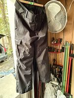 Full view of black Stormpack winter pants hanging