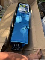 Box opened showing folded blue canopy chair in carry wrap