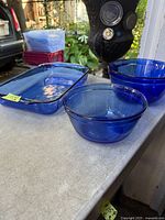 Shows cobalt blue Pyrex rectangular baking pan and two cobalt blue Anchor Hocking glass bowls on surface