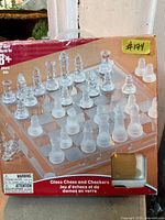 Front of retail box showing glass chess board and pieces