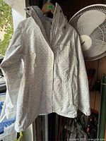 Front view of light grey patterned Columbia hooded jacket on hanger showing overall design