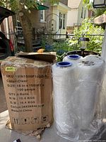 Cardboard carton and two visible rolls of clear stretch film