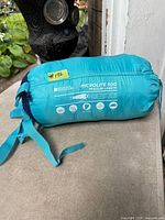 Sleeping bag in turquoise compression sack with straps