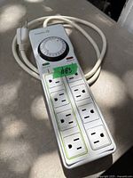 Full view of TrickleStar power strip showing timer dial, outlets, and cord