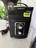 Front and side view of Westinghouse heater showing controls, grille, handle and power cord