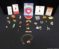 Overall lot of novelty pins and necklace arranged on black backdrop