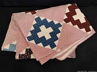 Folded quilt showing overall pattern and pink background