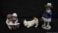 All three figurines grouped: girl with satchel, West Highland Terrier, children reading