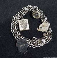 Bracelet front showing prayer plaque, elephant charm, camera charm