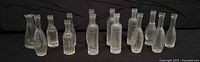 Front view showing all 15 clear glass mini bottles in two rows