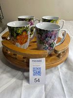 Four floral porcelain mugs on wooden lazy Susan