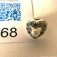 Front view of sterling silver heart ring with central pearl and surrounding green aventurine stones