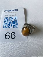 Ring with lot tag showing tiger eye gemstone and silver setting