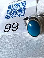 Front view of sterling silver ring showing turquoise howlite cabochon and 925 stamp card
